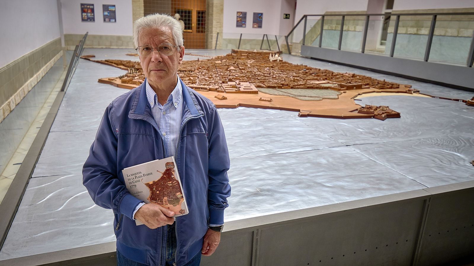 El historiador Rafael Garófano posa con su último libro ante la Maqueta de Cádiz.