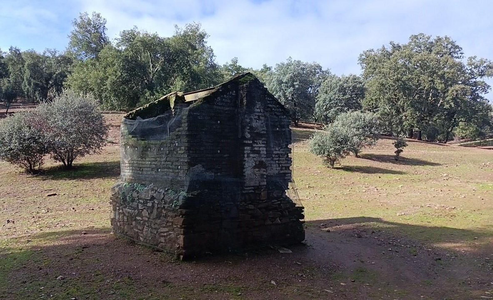 Al fondo hay un pozo con un tejado.