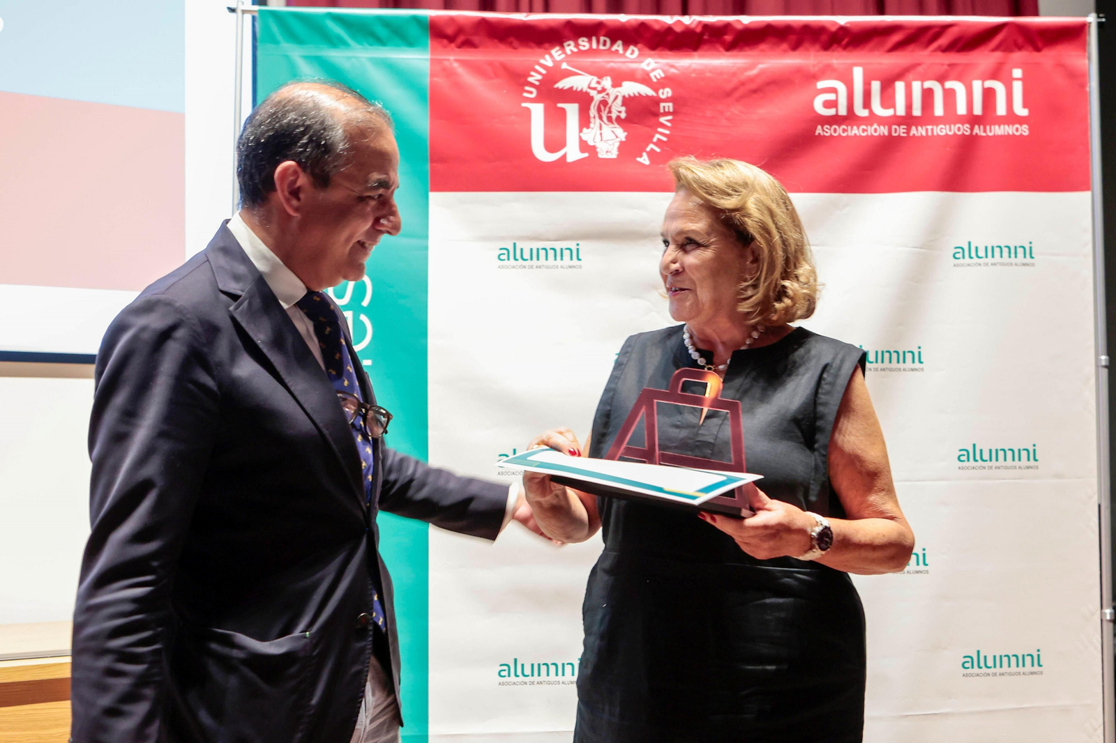Concha Yoldi recibe el Premio Honorífico Alumni 2023 de manos del rector Miguel Ángel Castro.