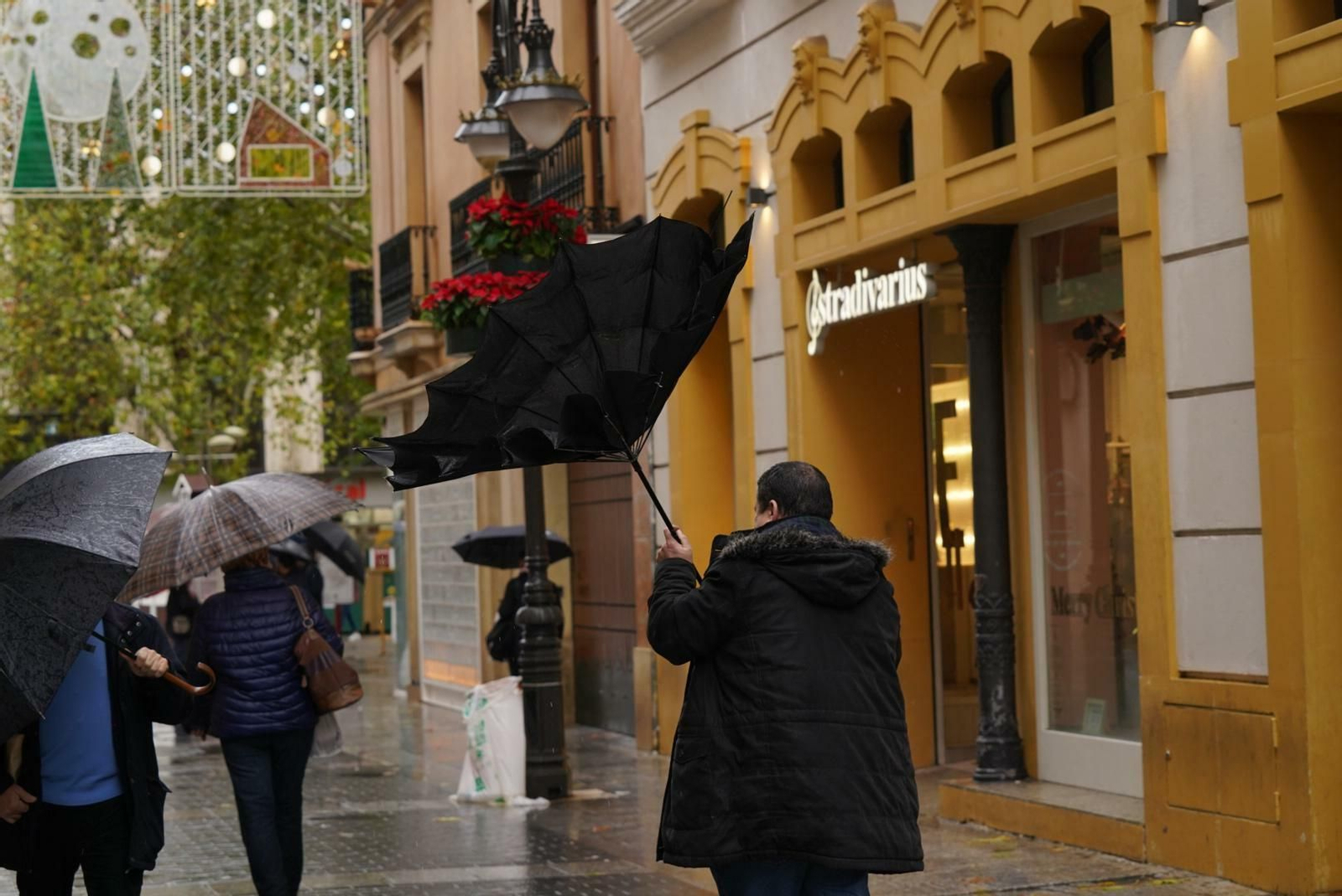 El viento voltea el paraguas de un hombre en la calle Gondomar.