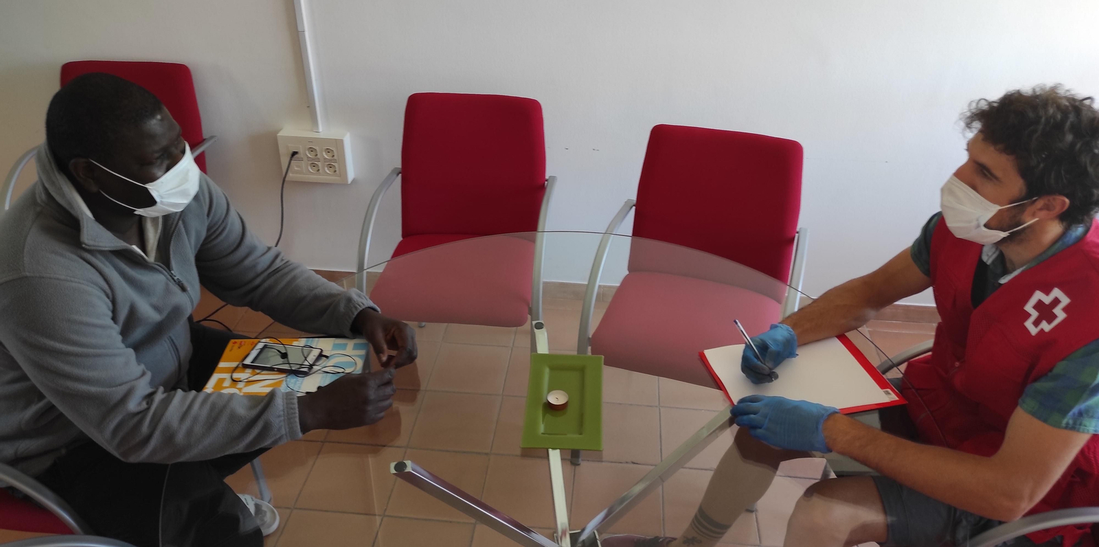 Un miembro de Cruz Roja atiende a un usuario.