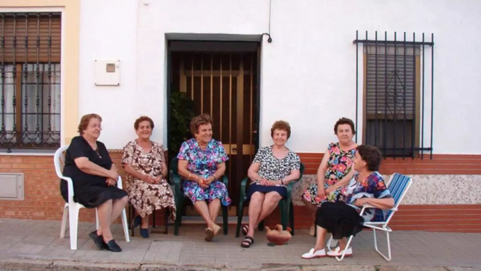 Grupo de mujeres tomando el fresco en la calle en un pueblo de Sevilla.