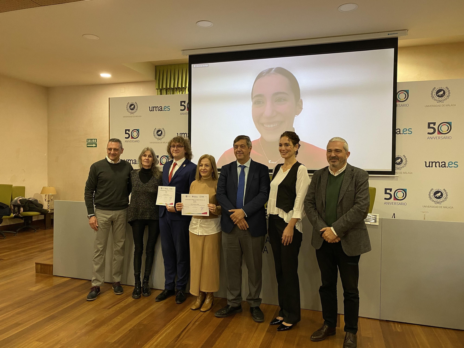 Los dos becados junto a sus familias, el rector de la UMA, la presidenta de la Fundación Kareema y el director general de FGUMA.