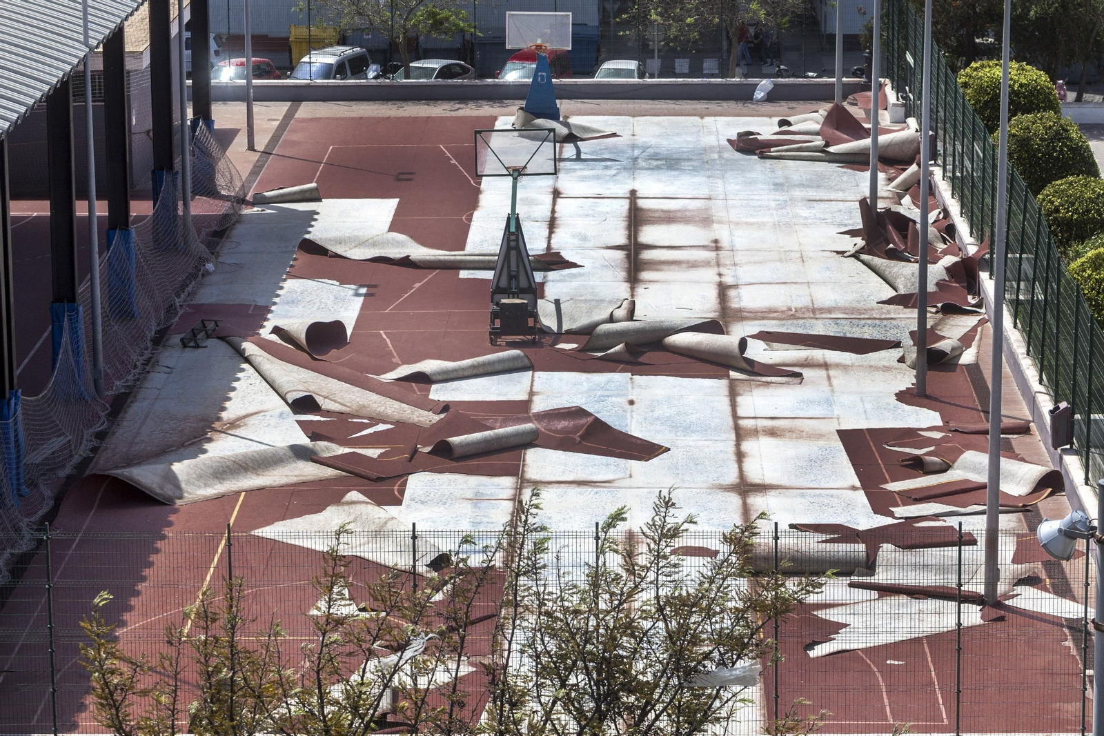 Operarios de mantenimiento retiran la arena acumulada en el paseo marítimo de Cádiz, a la altura de la calle Brasil.