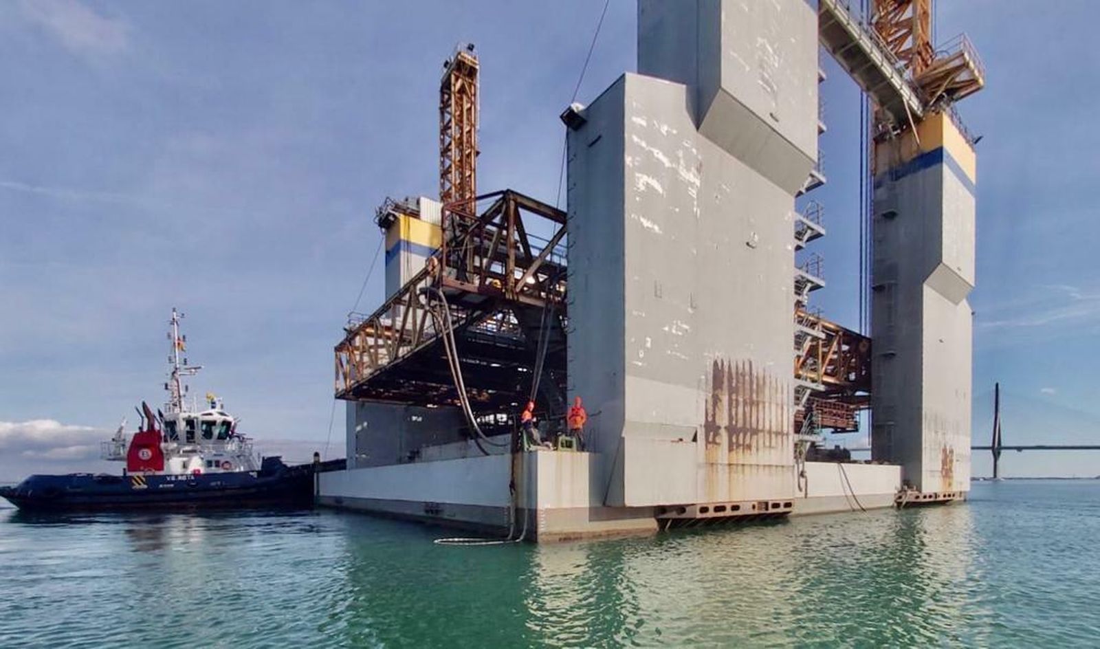 Los remolcadores del puerto deCádiz, en un momento del traslado de una de las plataformas cajoneras.