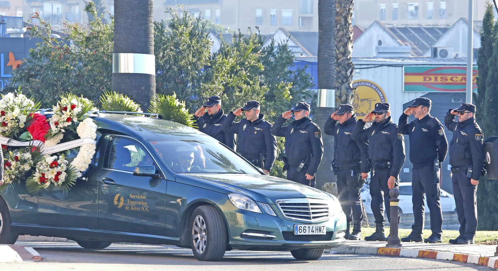 Compañeros del padre de la niña se cuadran al paso del coche fúnebre.