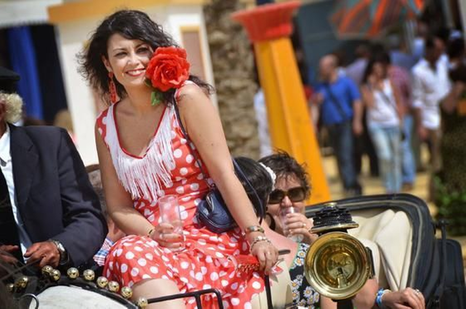 Colorido. Una joven luce sus mejores galas mientras pasea en coche de caballos por la Feria.  

Foto: Manuel Aranda