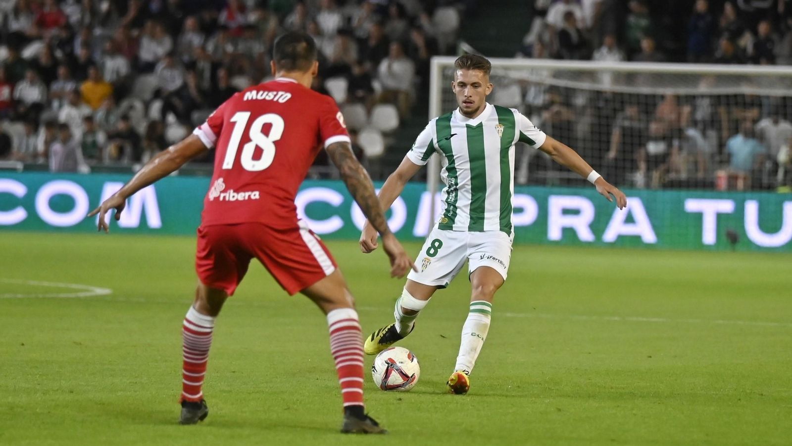 Isma Ruiz pasa el balón en presencia de Musto en el Córdoba CF - Cartagena.