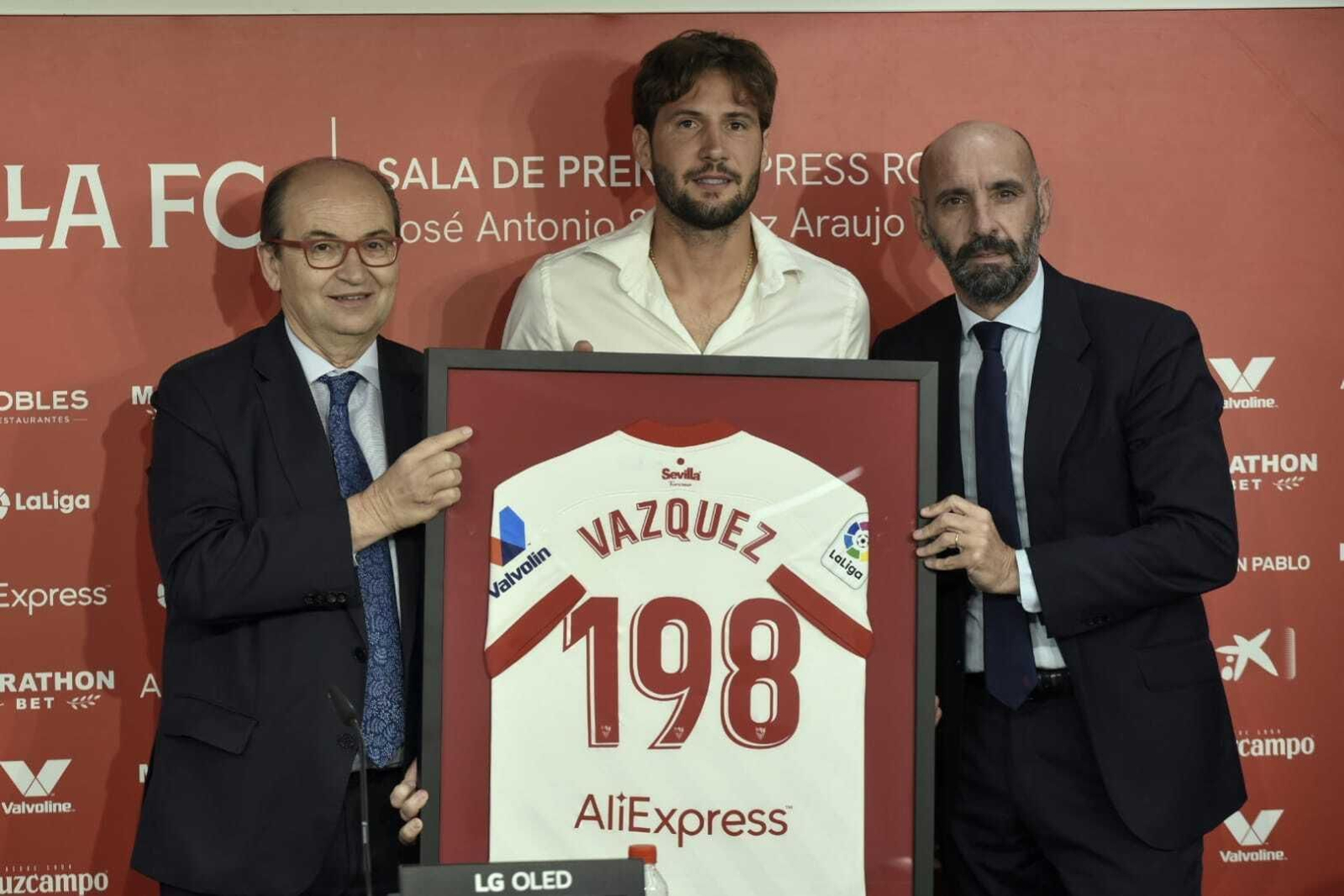 Franco Vázquez, con el presente que le hizo el club y flanqueado por Castro y Monchi.