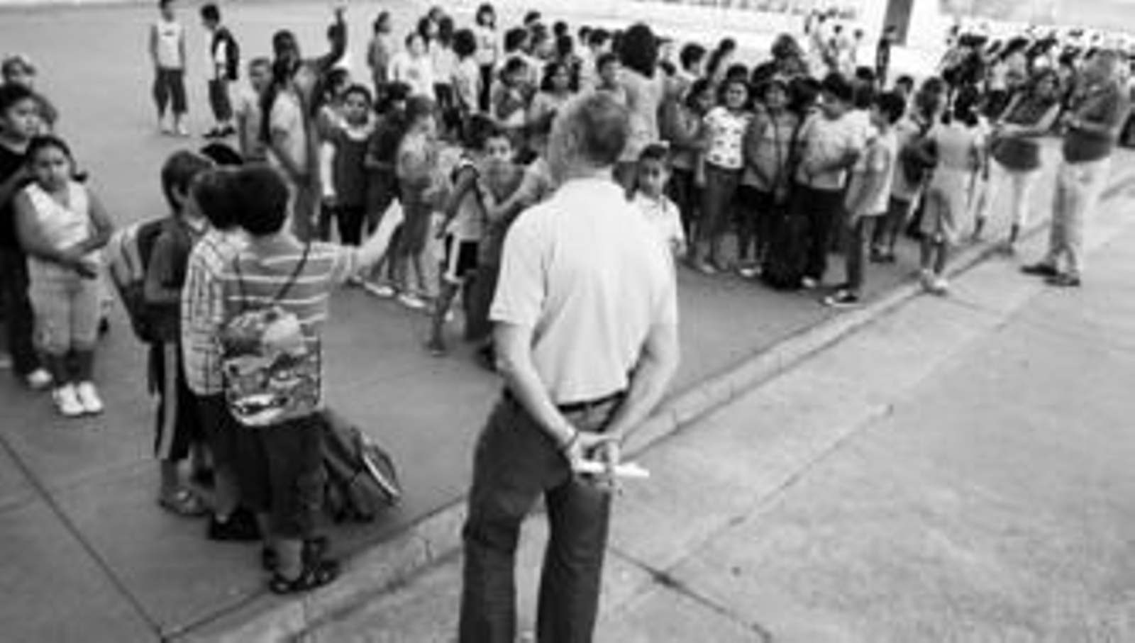 Los tutores de curso organizan a sus pupilos en el patio del colegio antes de entrar en las aulas.