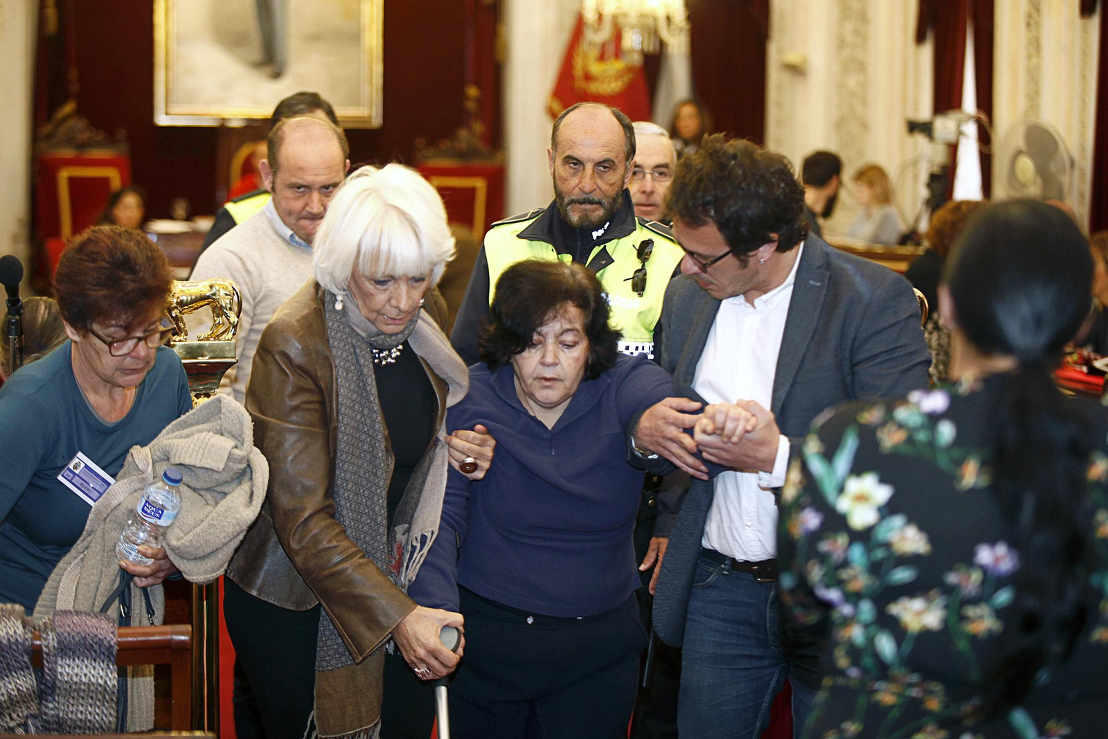 Teófila Martínez y José María González, acompañando a la mujer a salir de la sala de plenos.