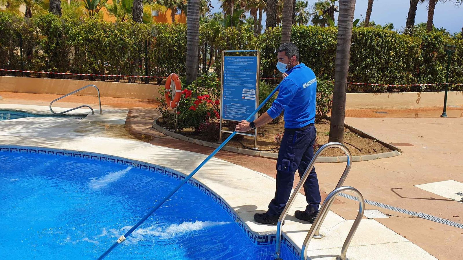 Un operario limpia la piscina del apartahotel Playamarina, en Ayamonte.
