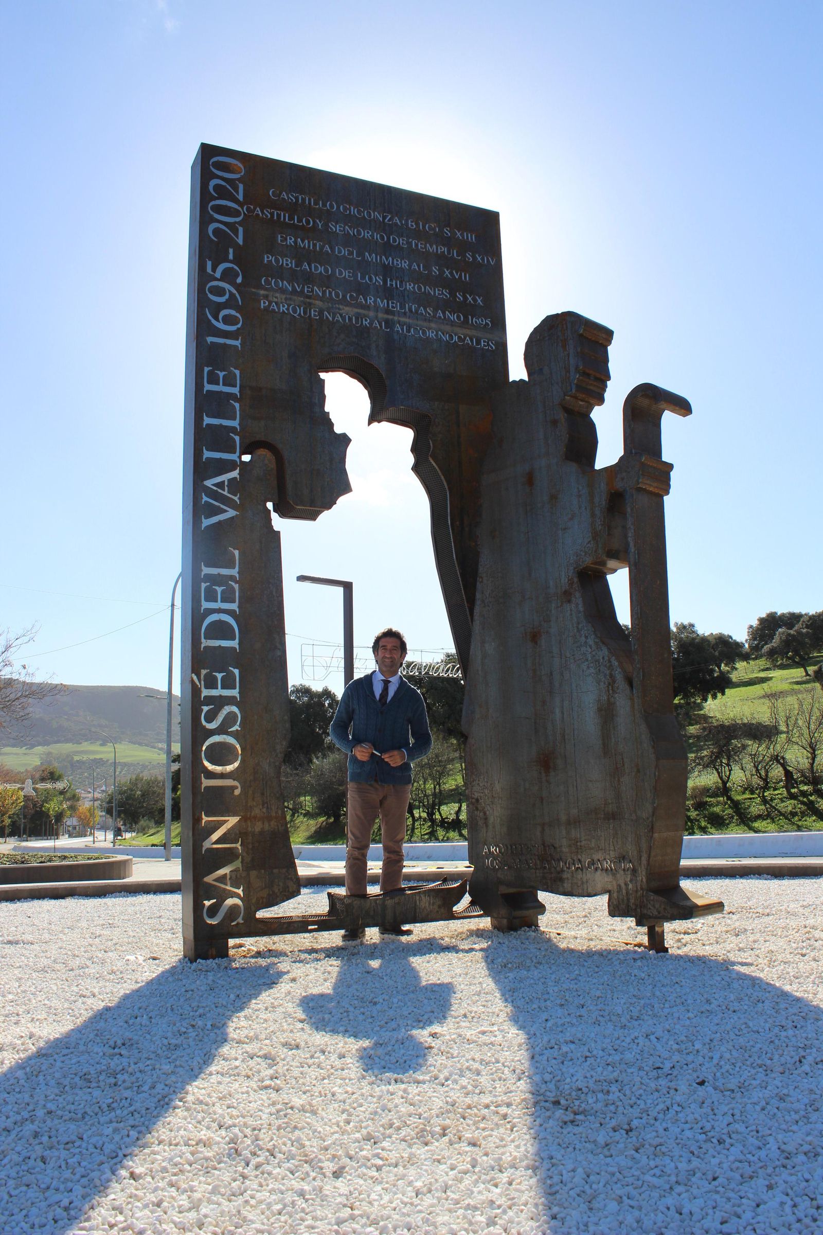 José María Vega al lado de otra de sus obras, la escultura de la Plaza de acceso a San José del Valle.