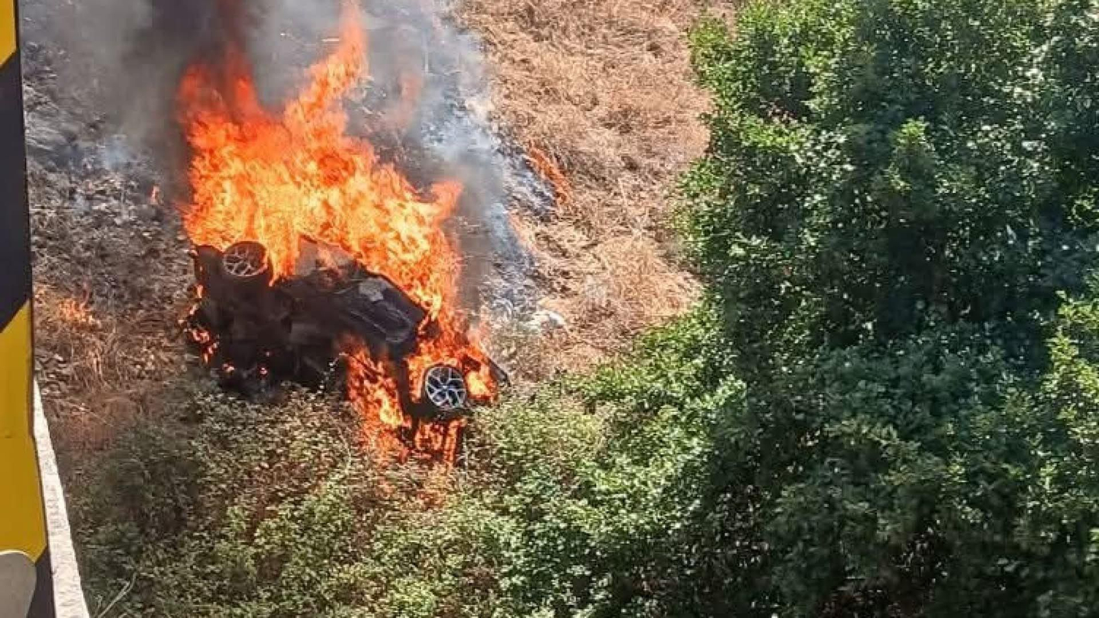 El coche envuelto en llamas tras caer de un puente.