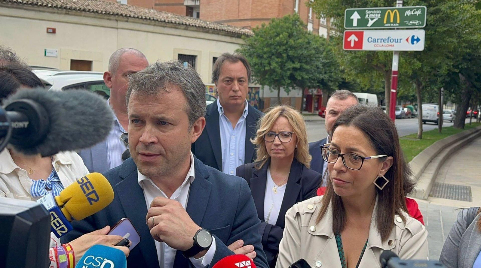 Julio Millán atiende a los medios de comunicación, en presencia de África Colomo y resto de miembros socialistas.