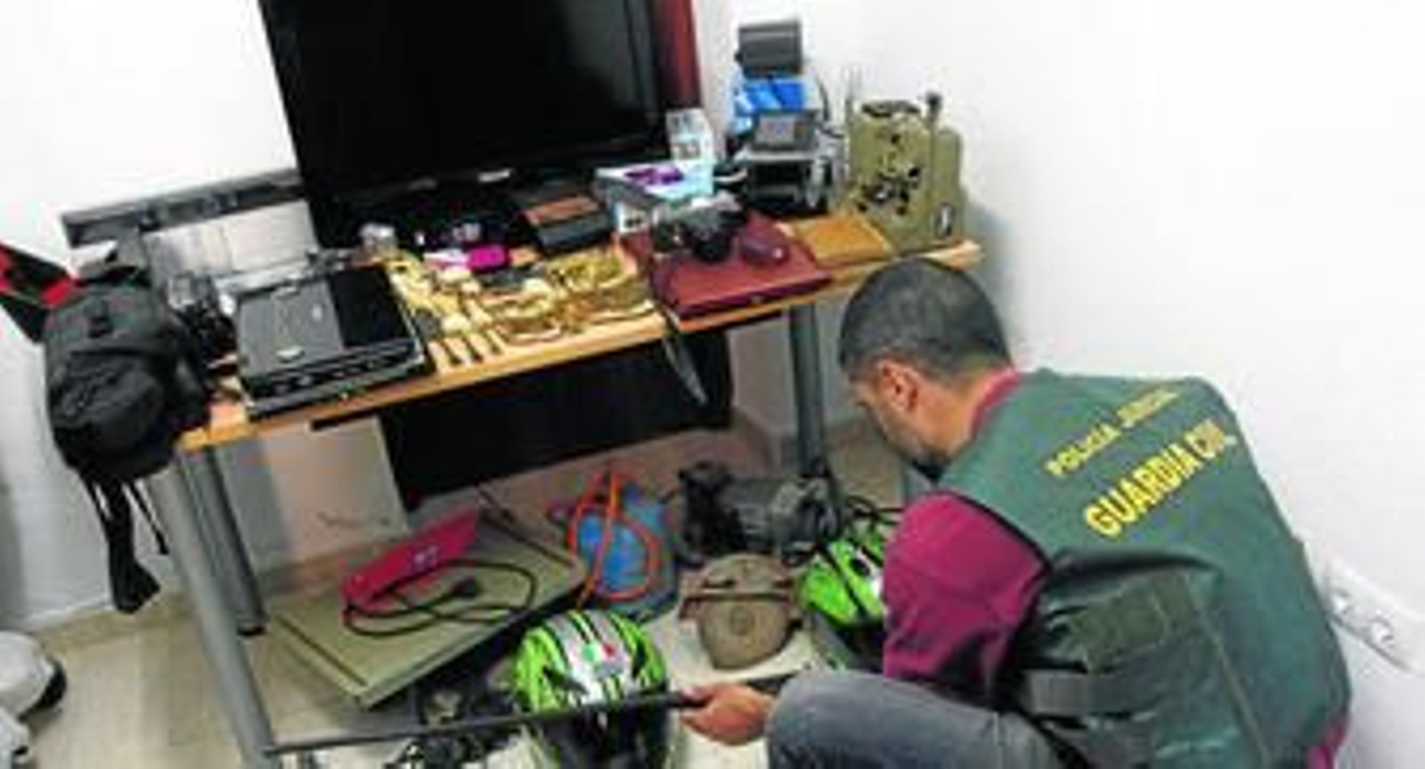 Un agente de la Guardia Civil manipula los objetos requisados a un ladrón que fue detenido tras asaltar más de una treintena de casas en Espartinas.