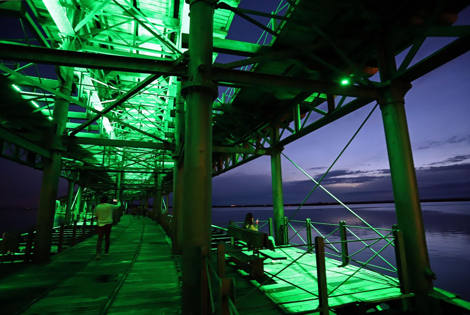 El muelle de la Riotinto se ilumina de verde en el día mundial contra el cancer