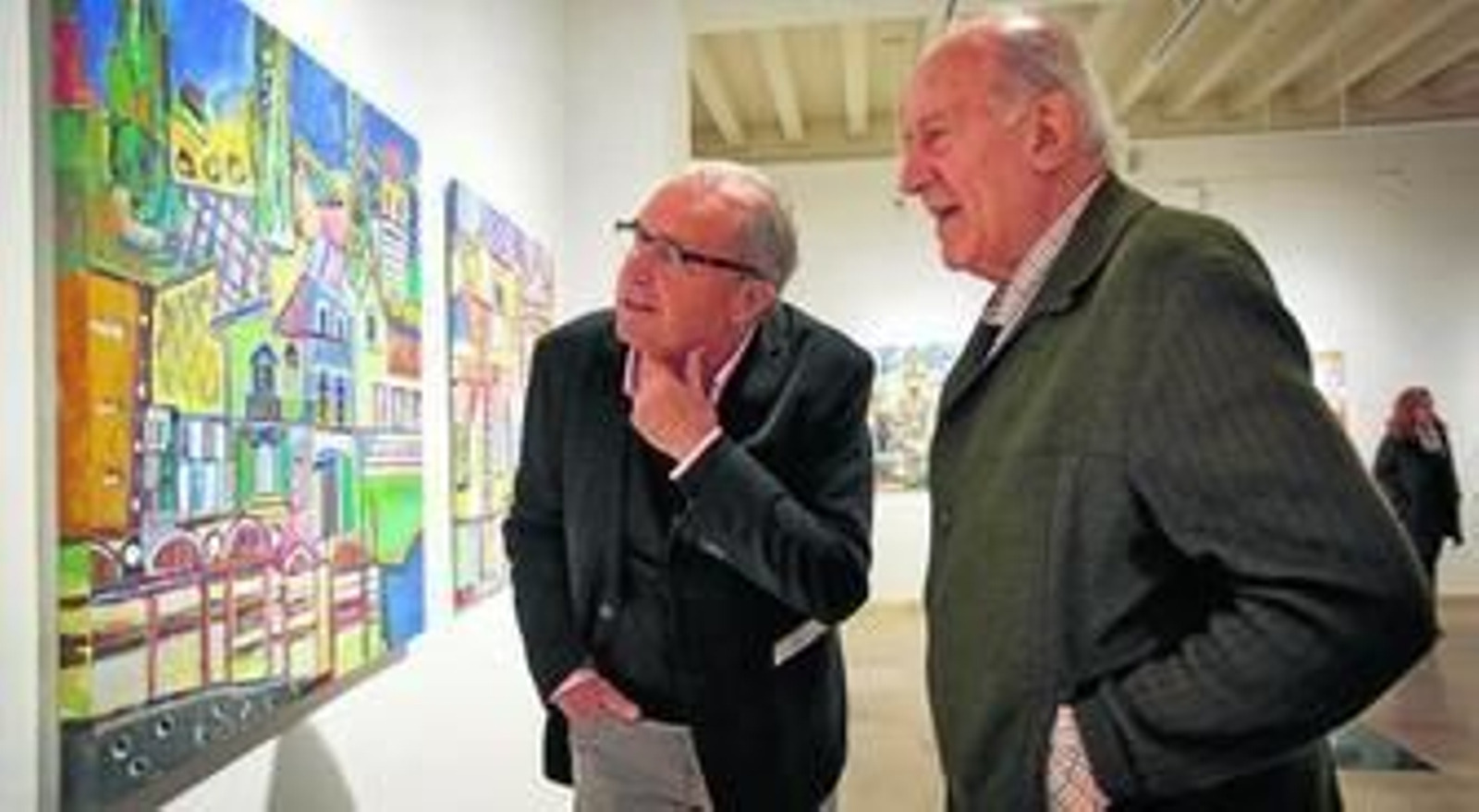 José Manuel Paredes (izquierda) comenta una de sus obras con un visitante a la sala de la Fundación Cajasol.