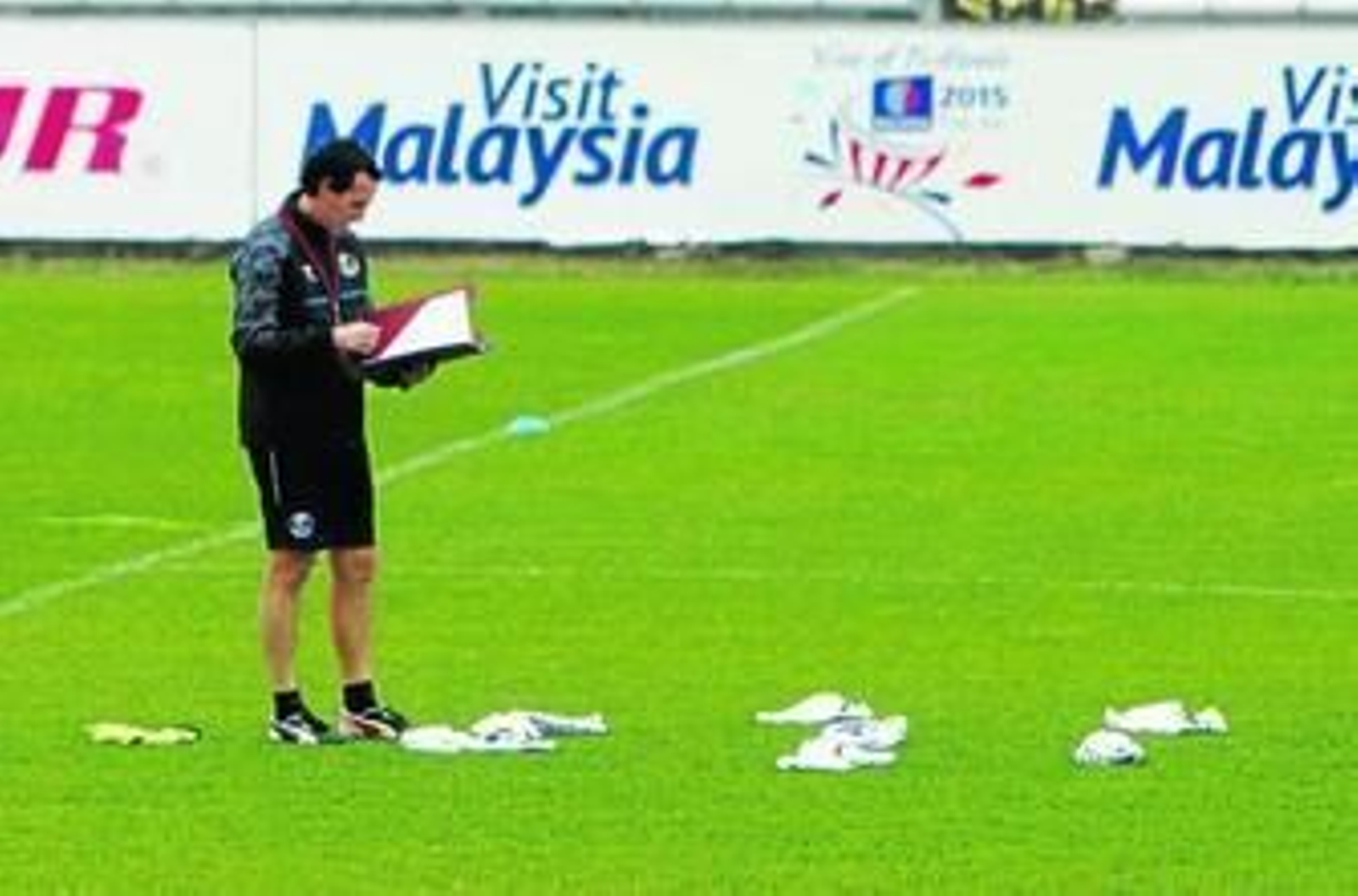El entrenador del Sevilla, Unai Emery, repasa unas anotaciones en pleno trabajo en la ciudad deportiva.