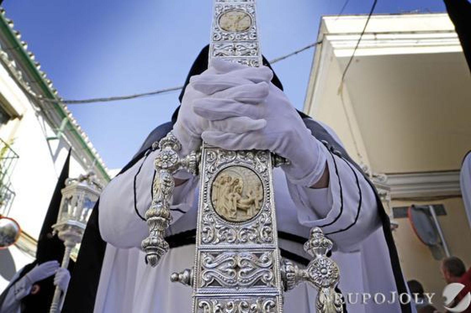 El hermano de La Coronación que porta la cruz de guía y abre la estación de penitencia hace una parada en la calle Bizcocheros.

Foto: Manuel Aranda