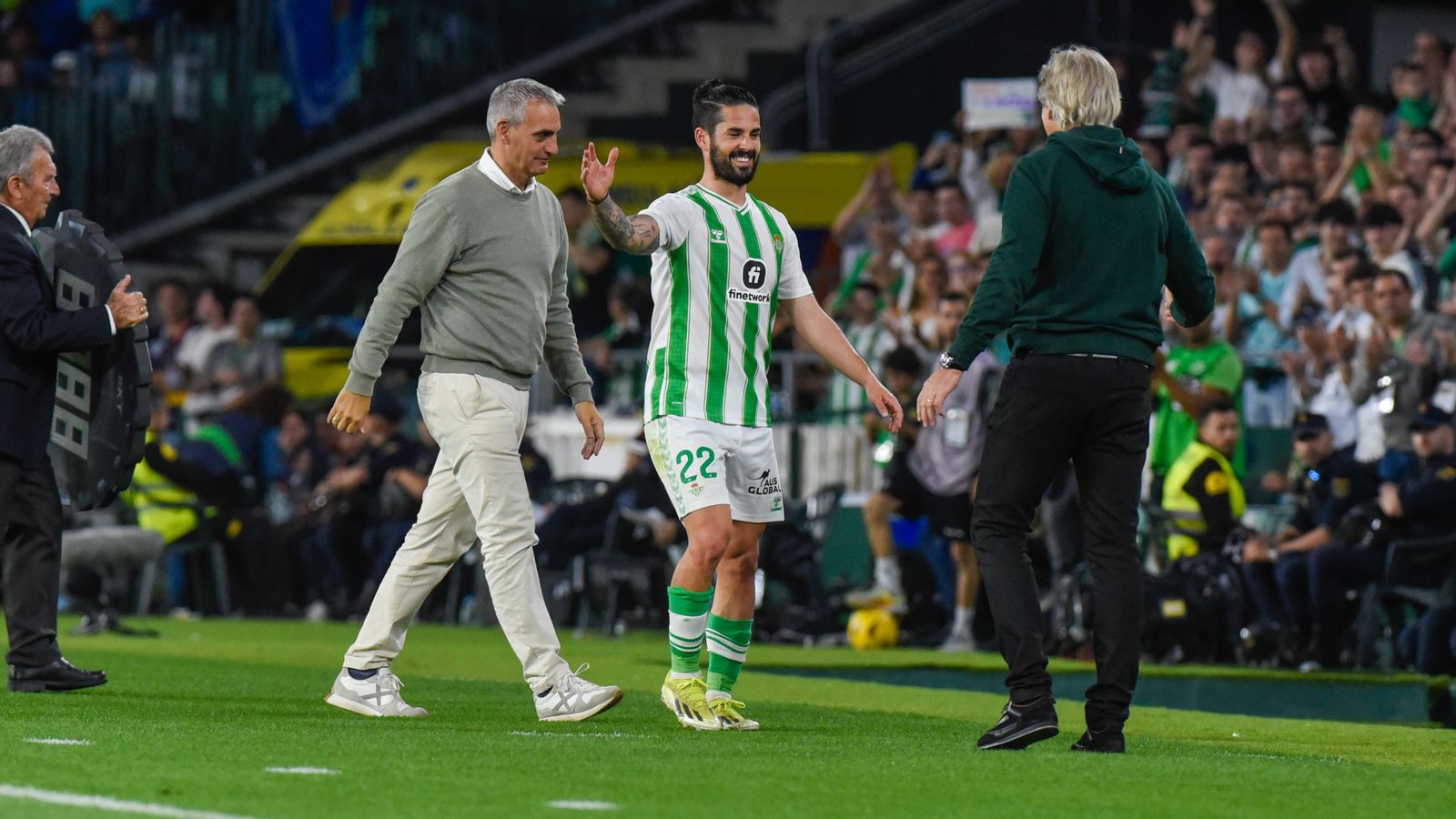 Manuel Pellegrini se dispone a felicitar a un Isco sonriente y contento con su partido y el marcador en el momento de ser cambiado en los últimos minutos del choque.