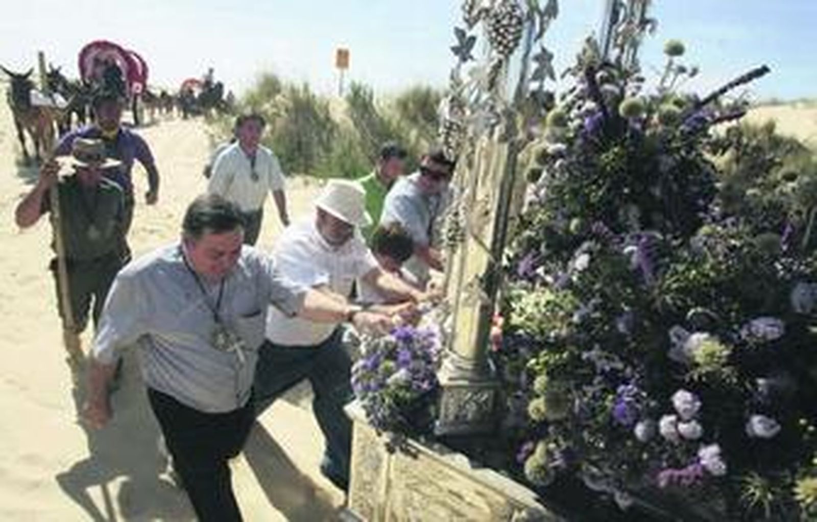 El obispo José Mazuelos, ayer agarrado a la carreta del Simpecado por el Cerro de los Ánsares.