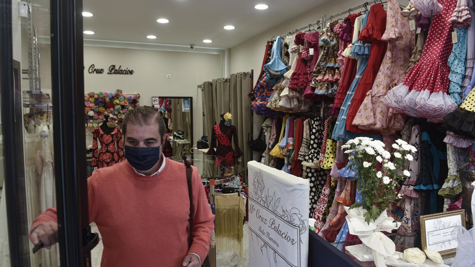 Un comerciante abre su negocio de moda flamenca.