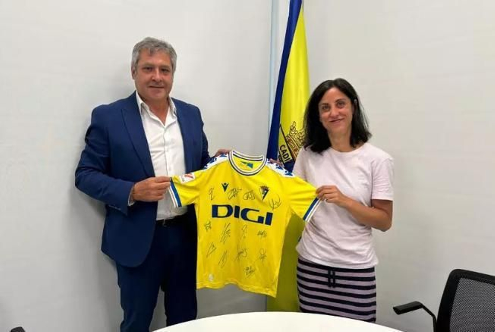 Entrega de una camiseta del Cádiz durante la firma del convenio.