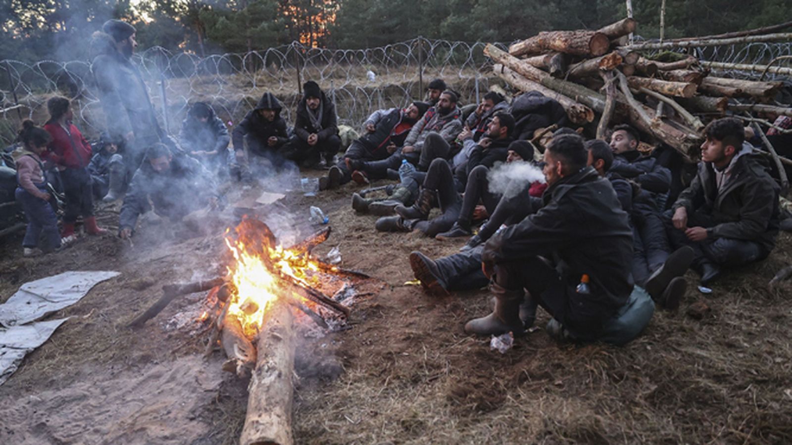 Migrantes se protegen del frío en la frontera entre Polonia y Bielorrusia.