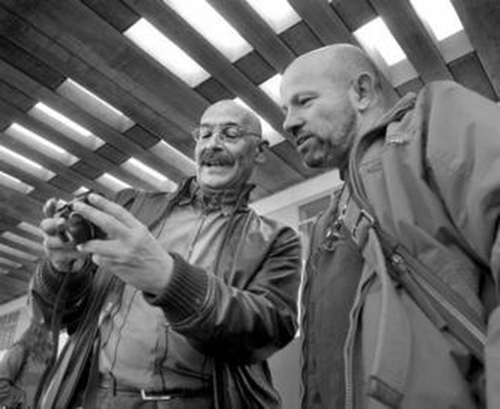 Pablo Juliá, a la izquierda, muestra una fotografía a Ilan Wolff.