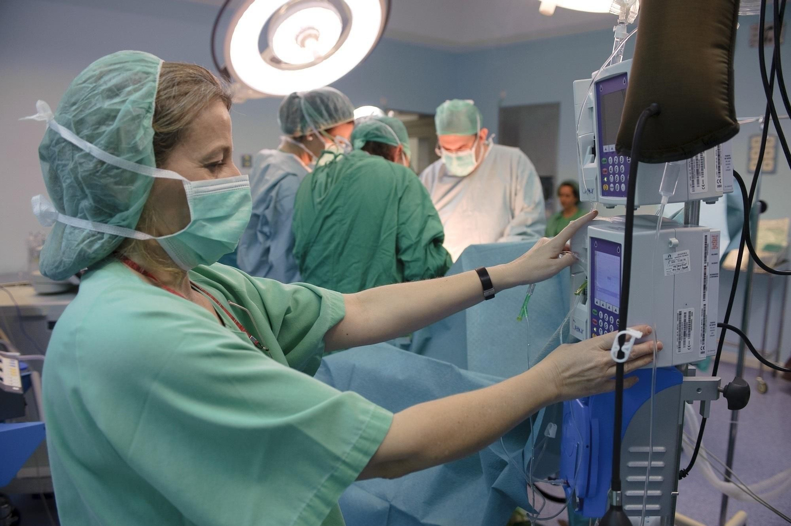 Una enfermera  controla las constantes de un paciente en quirófano.