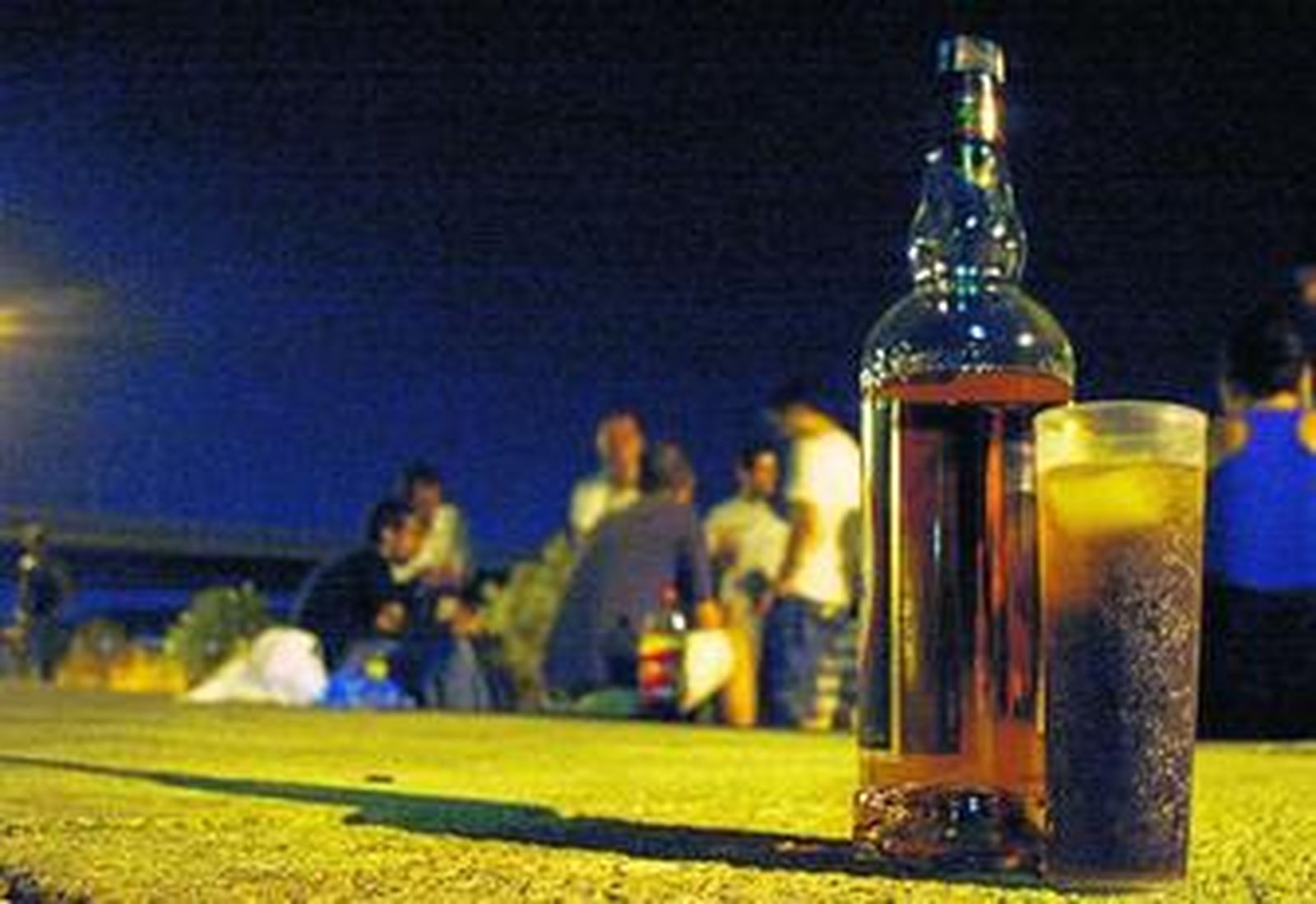 Un grupo de jóvenes haciendo 'botellona' en el Paseo de Rey Juan Carlos I, frente a la isla de la Cartuja.
