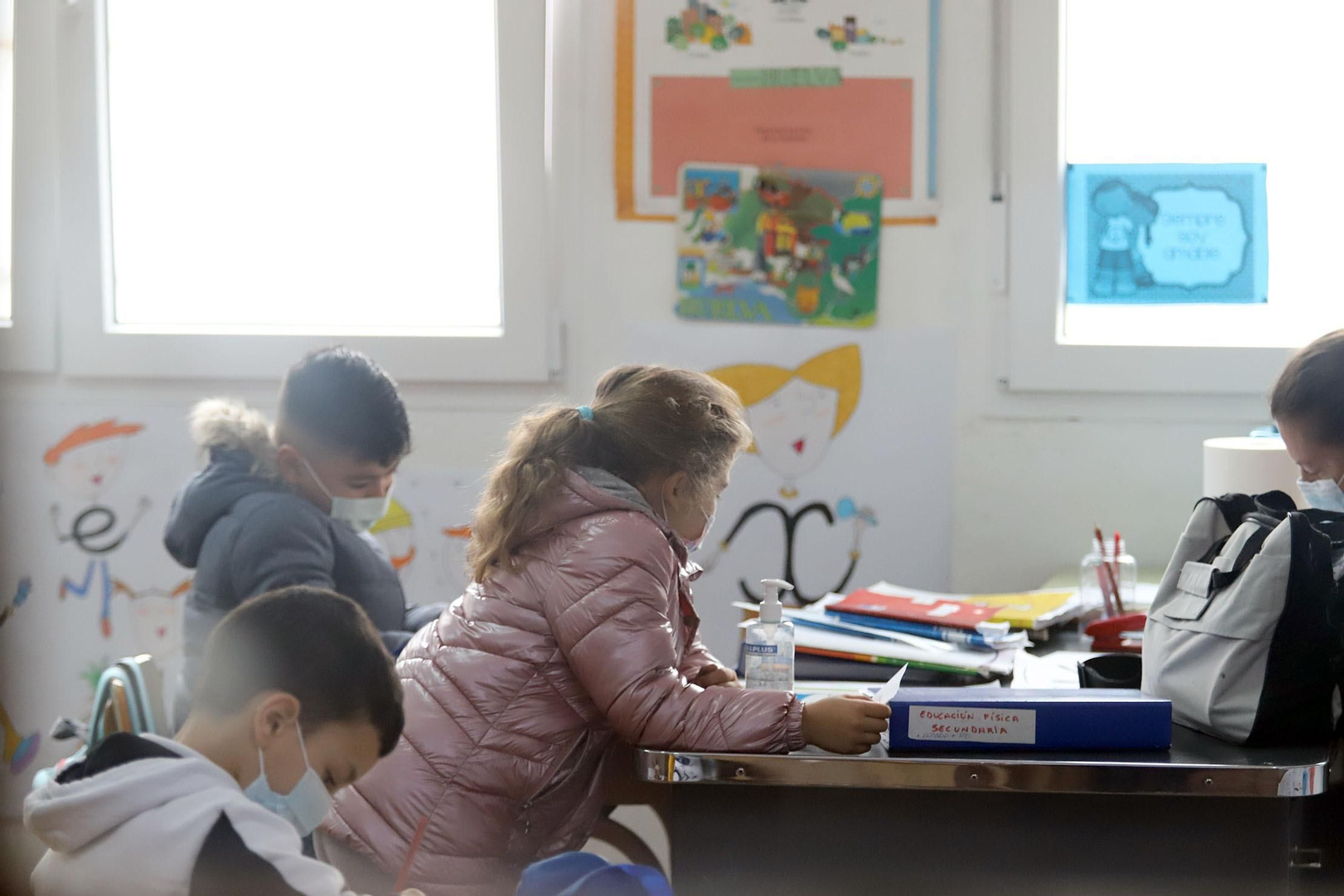 Escolares con sus abrigos en el aula, con las ventanas abiertas para favorecer la ventilación.