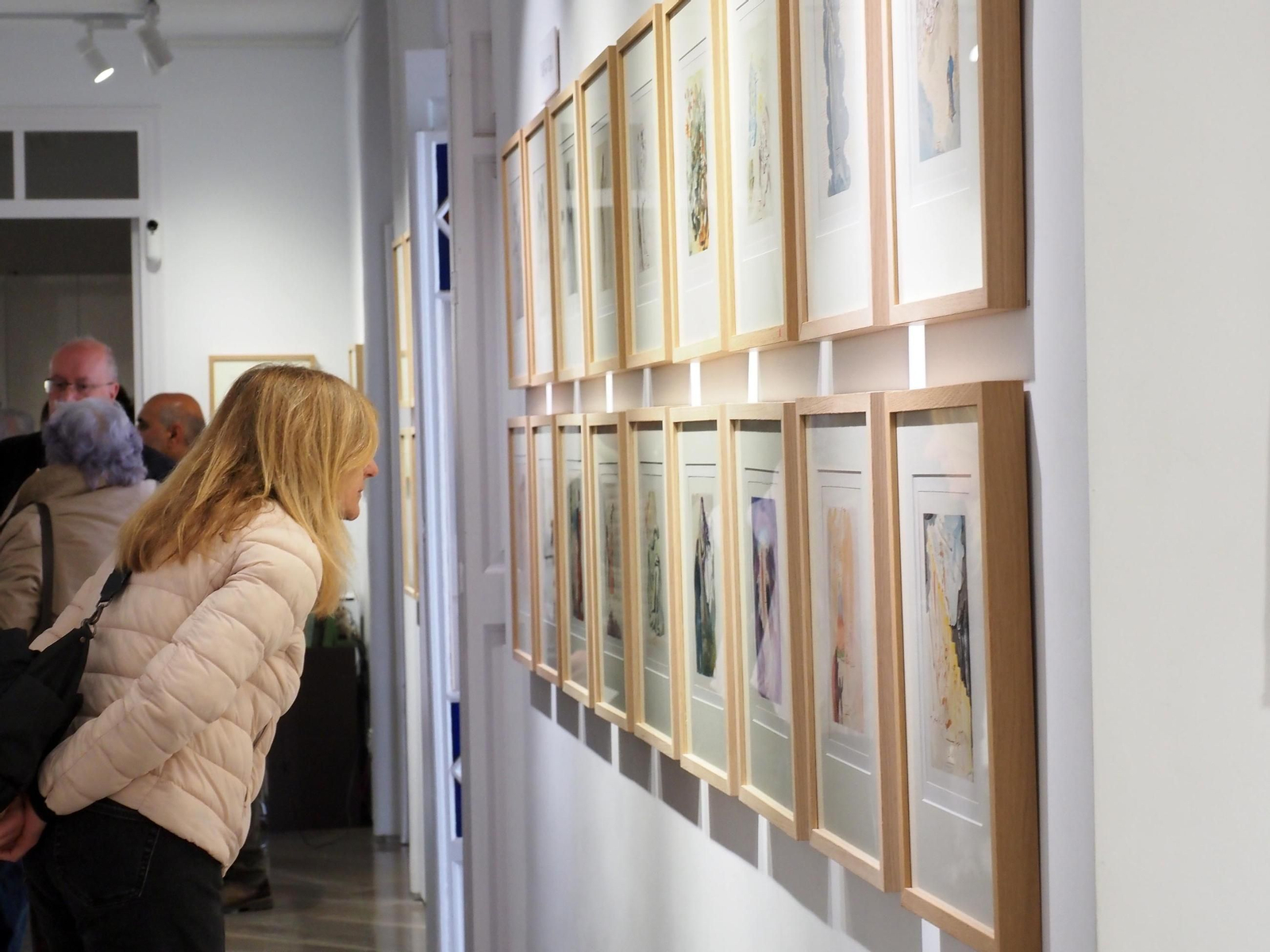 Una asistente observa con detenimiento una de las xilografías de Salvador Dalí en Lepe