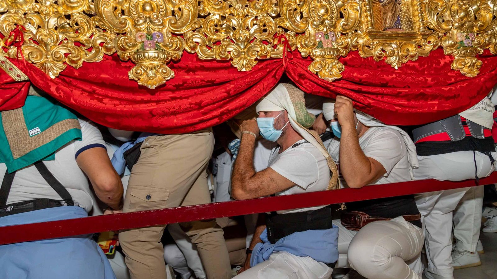 Los costaleros de la Patrona de Isla Cristina descansan en una parada del paso