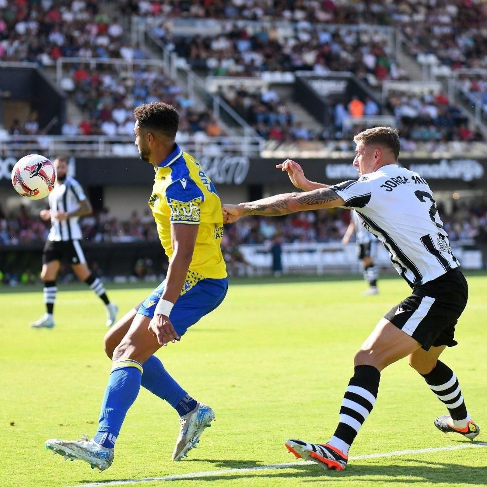 Chris Ramos protege el esférico ante la presión de Jorge More.