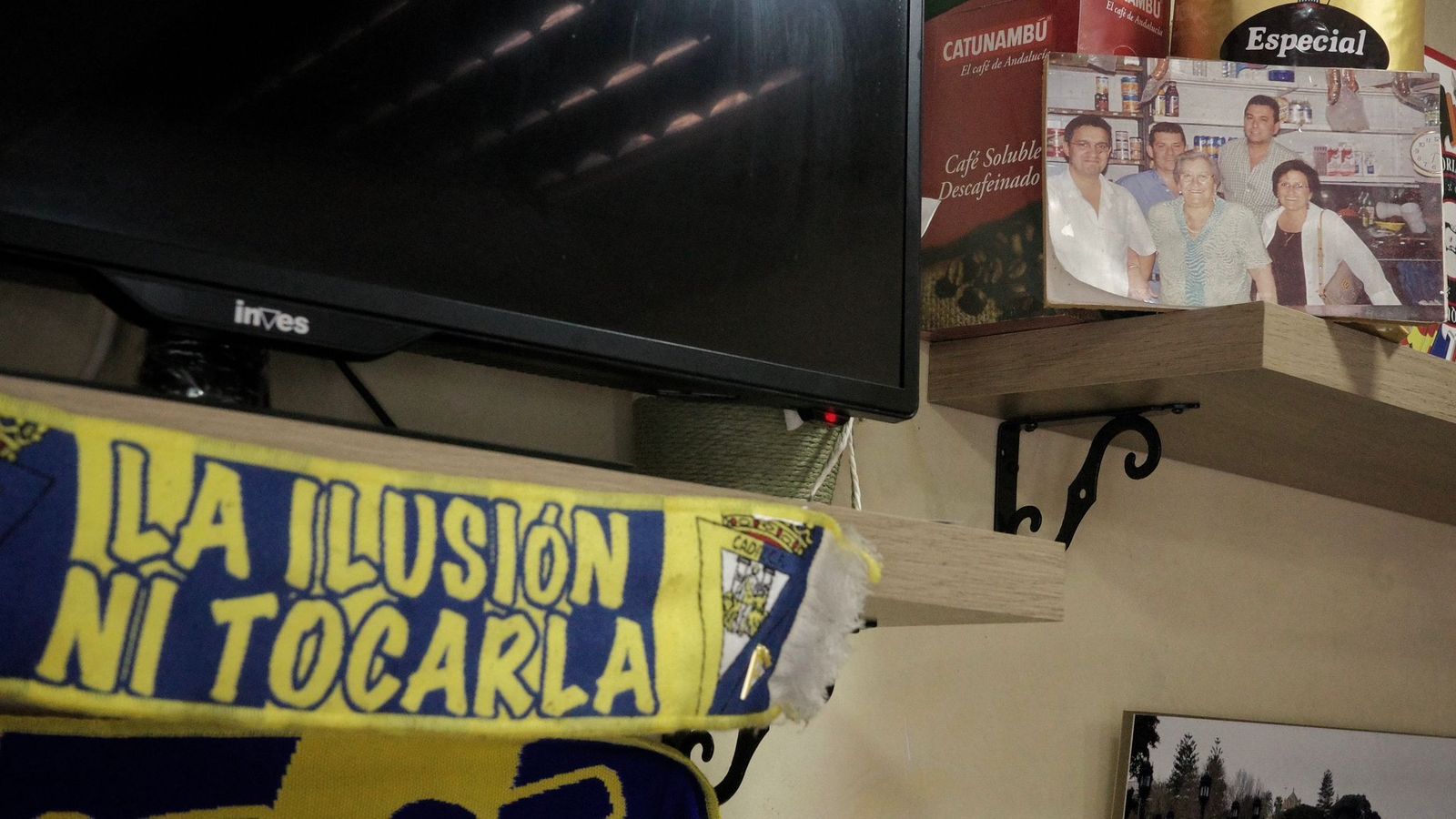 Una foto de la familia Rivas, junto a la bufanda del Cádiz, en el negocio de Pepe Rivas.