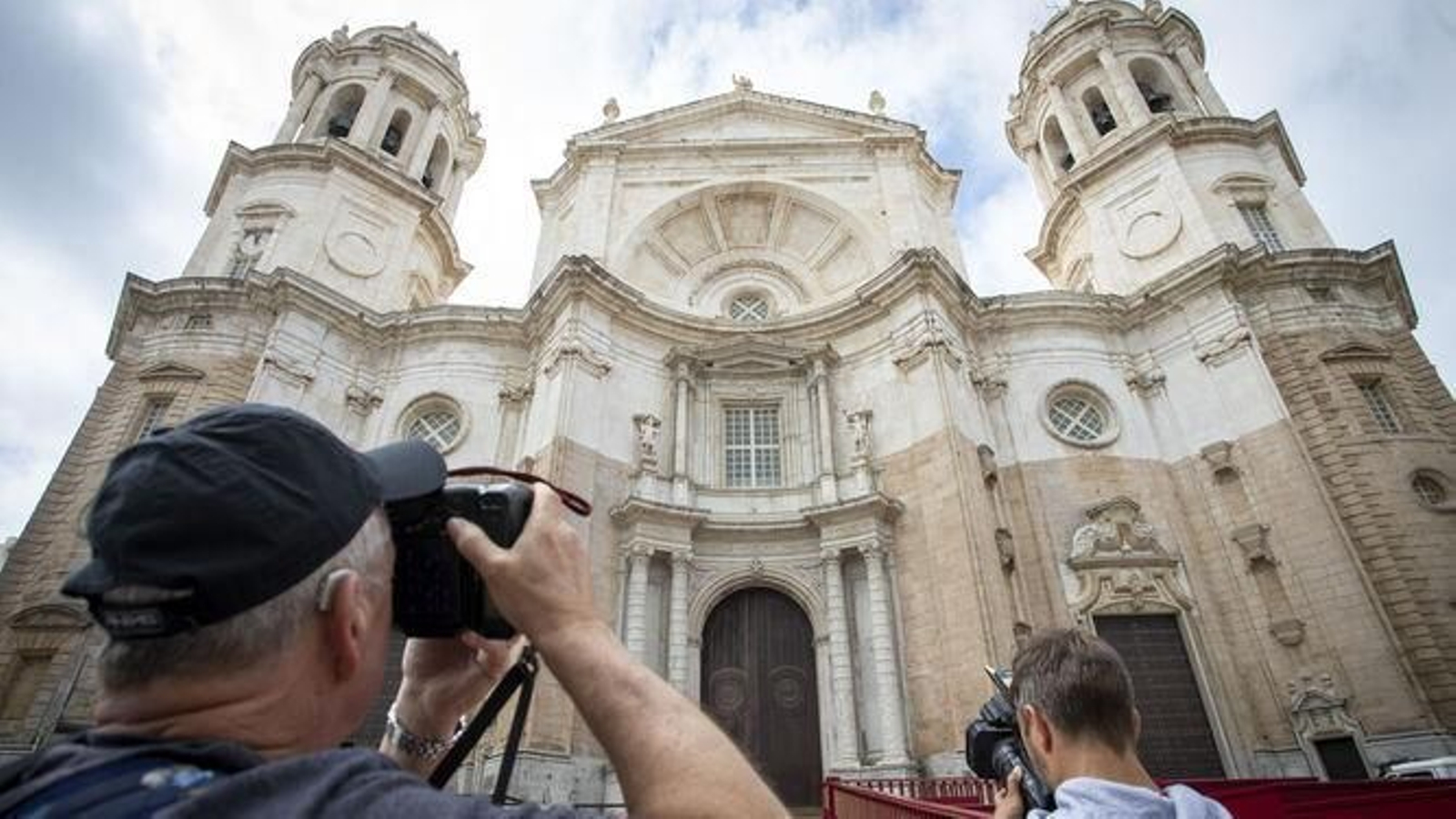 Un turista de la tercera edad fotografía la Catedral de Cádiz