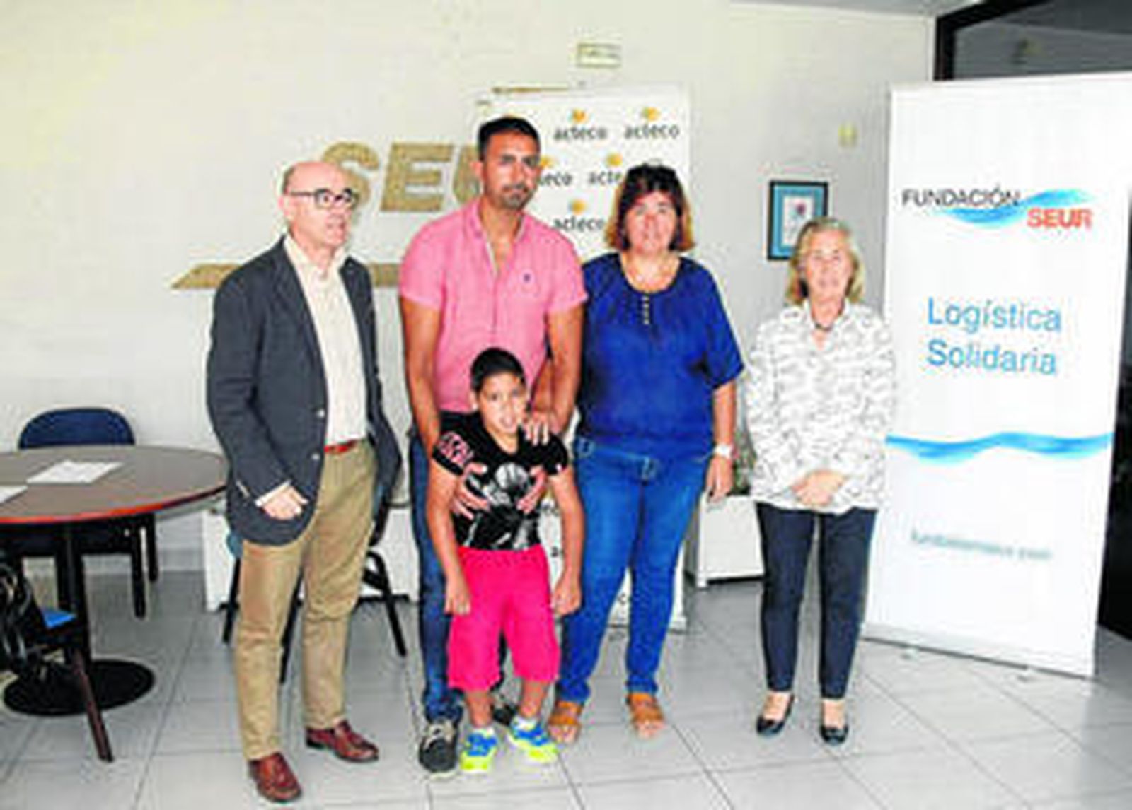 Una imagen de Adrián Medina junto a sus padres y representantes de la Fundación SEUR durante la entrega del cheque.