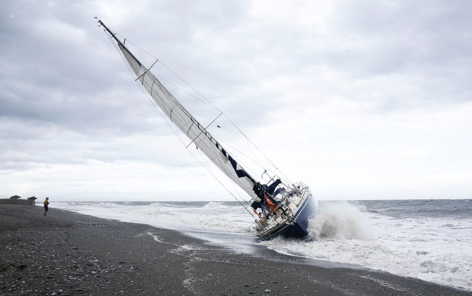 Fotos del velero encallado en la playa de Benajarafe, tras quedar a la deriva por el viento