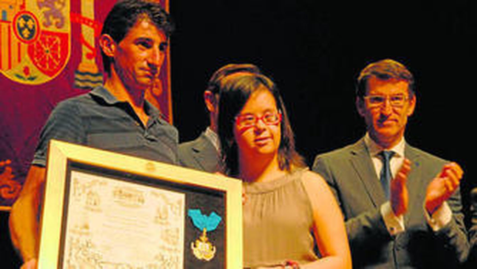 La joven superviviente del accidente, Fátima Reyes, con Francisco Otero, vecino de Angrois. Tras ellos, Núñez Feijóo.