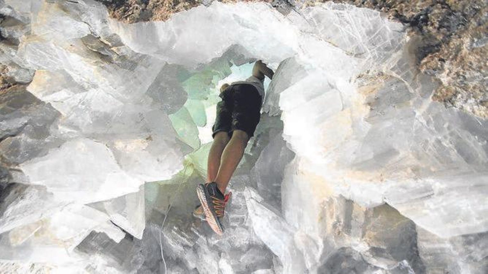 Un visitante se asoma por la cavidad para ver el interior de la geoda de Pulpí