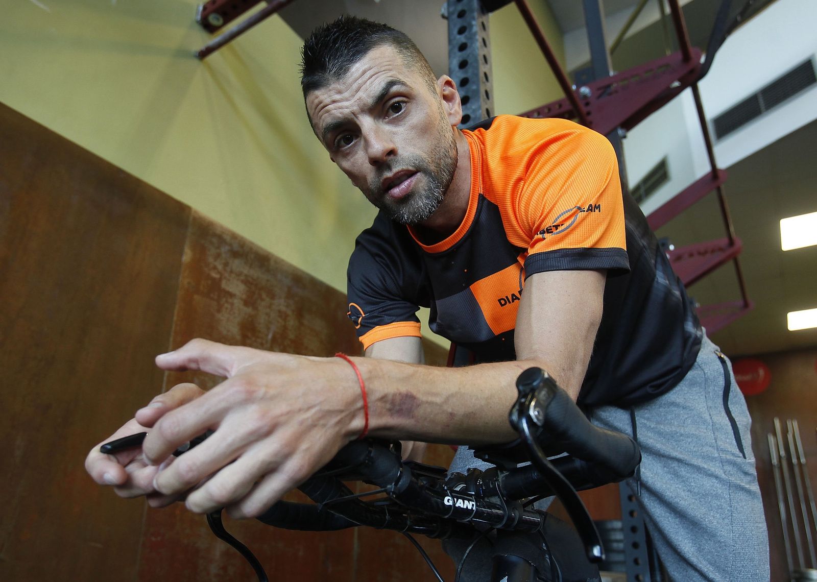 Nene posa subido a su bicicleta en el gimnasio aljarafeño Low Fit, donde acostumbra a trabajar como monitor de algunas actividades.