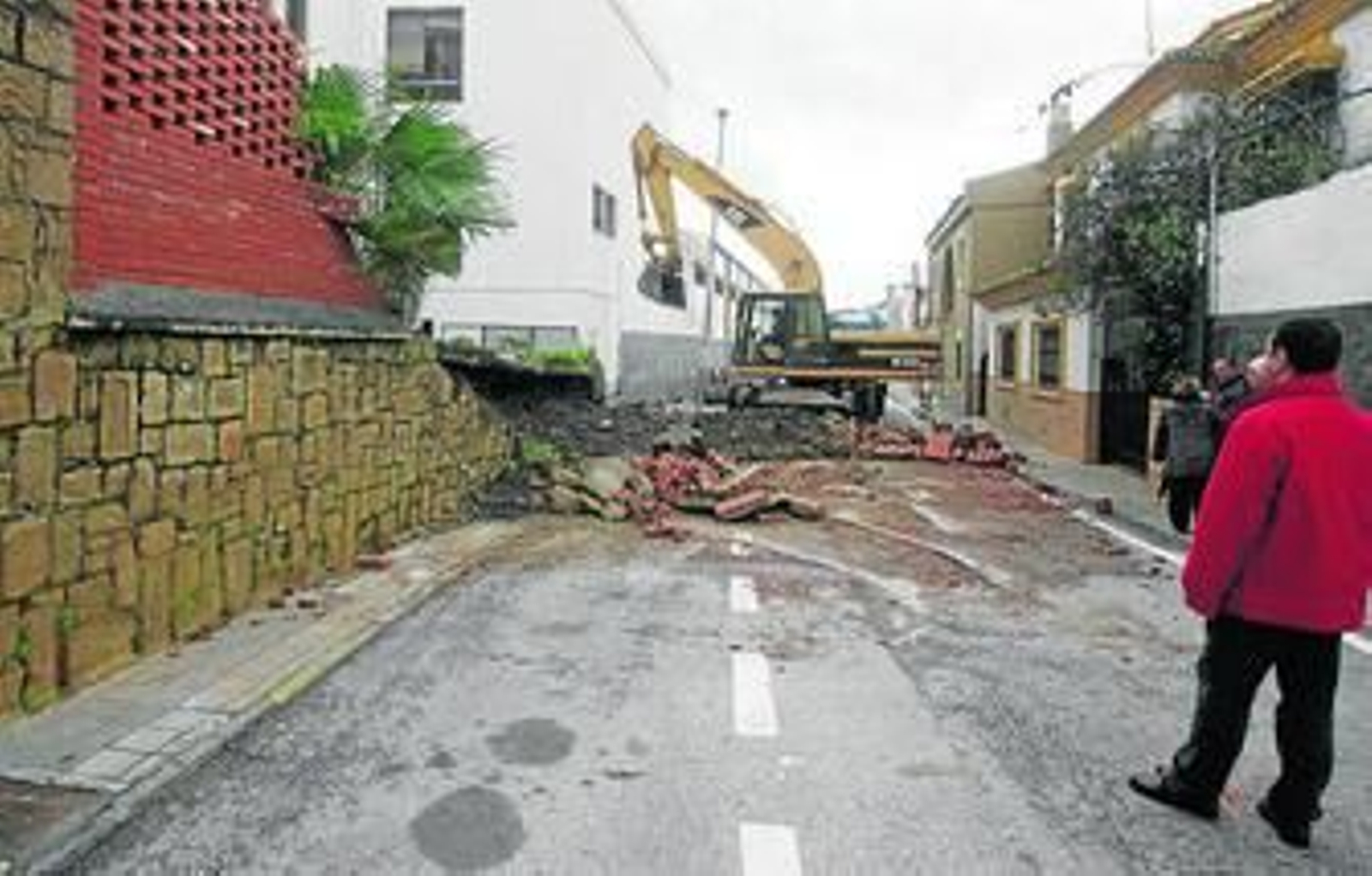 Una grúa retira restos tras caerse el muro de los Salesianos.