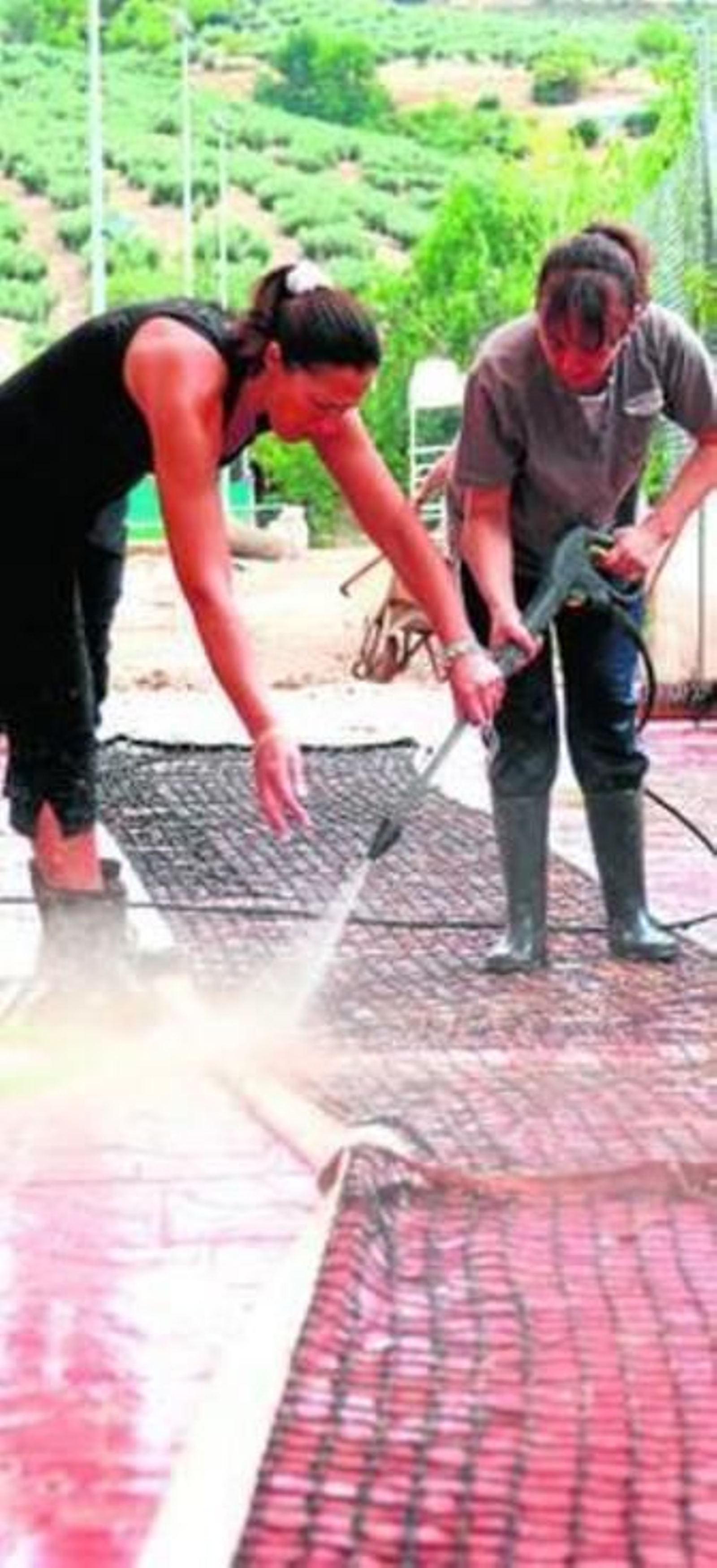 Dos mujeres retiran el lodo tras la inundación en Deifontes de agosto.
