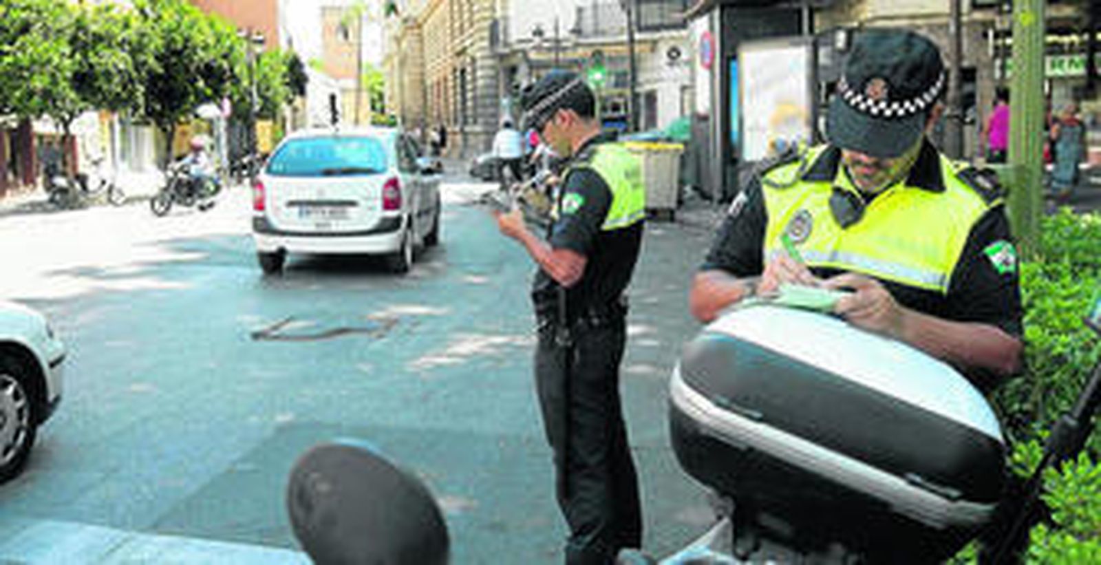 Dos agentes municipales anotan las matrículas de los vehículos que entraban ayer por Almirante Apodaca.