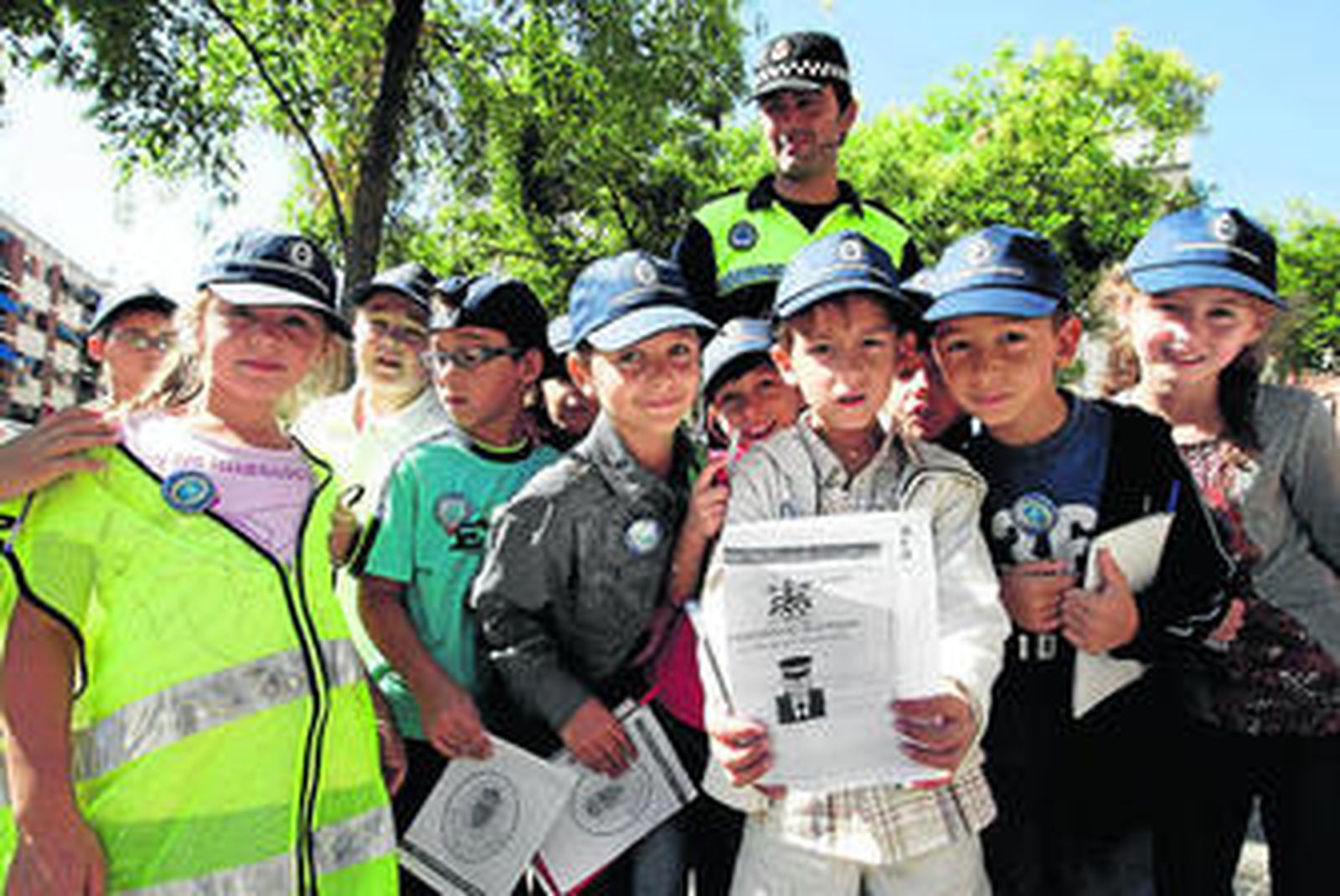 Algunos de los niños que formaron parte de la Patrulla Infantil Policial posan junto a un agente de la Policía Local.