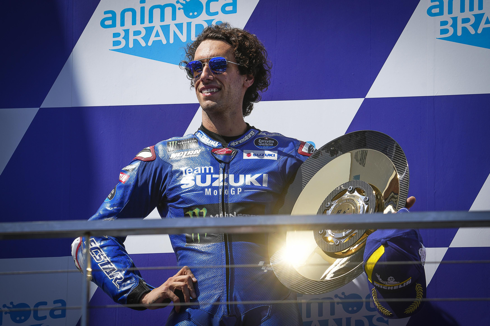 Álex Rins posa sonriente con el trofeo de campeón en Australia.