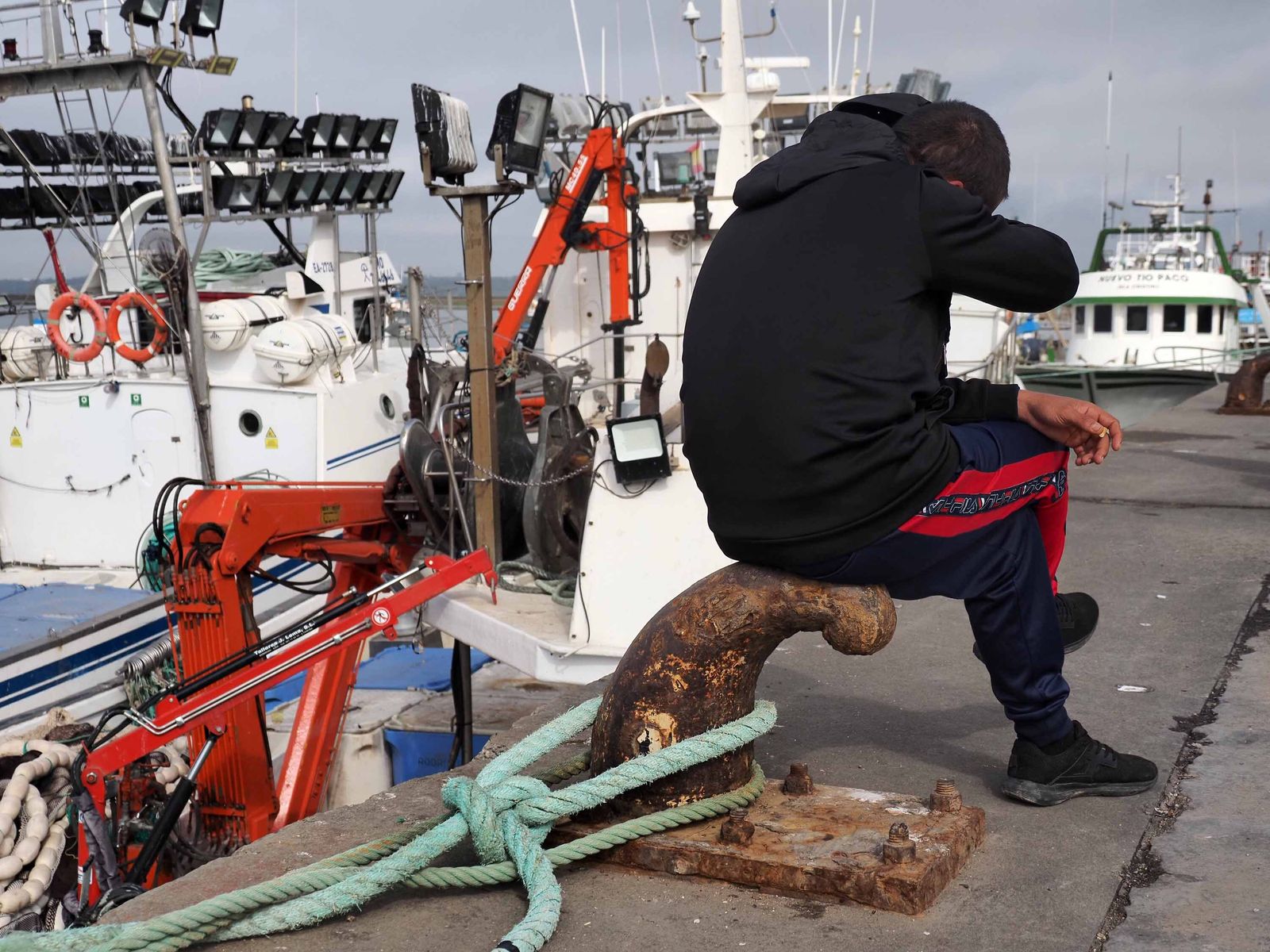 Un pescador sentado sobre un noray del puerto de Isla Cristina, con la flora amarrada, la pasada semana