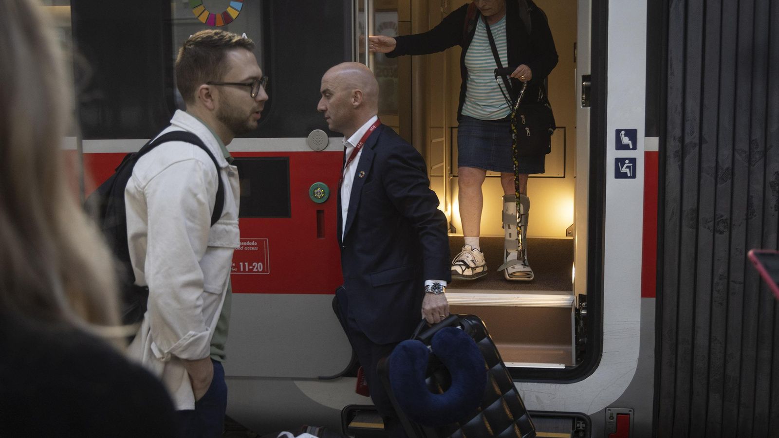 Gorini ayuda a una pasajera con su maleta minutos antes de partir el tren.